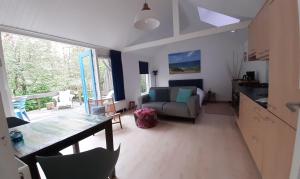 ein Wohnzimmer mit einem Sofa und einem Tisch in der Unterkunft Boshuisje Petten aan Zee in Petten
