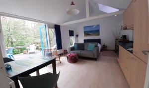 a living room with a couch and a table at Boshuisje Petten aan Zee in Petten +16 photos