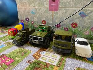 dwie ciężarówki i zabawkowy samochód na stole w obiekcie Гостевой дом "Маячок" w mieście Gelendżyk