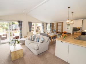 a kitchen and living room with a couch and a table at Seagull Lodge in Runswick