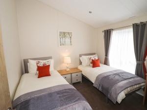 a bedroom with two beds and a window at Seagull Lodge in Runswick