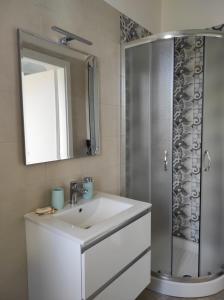 ein Badezimmer mit einem weißen Waschbecken und einer Dusche in der Unterkunft Nonno Rocco in Castro di Lecce