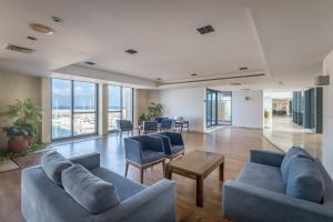 a living room with couches and a table and windows at Front of Beach next Ritz Hotel - 3 Bedroom& 3 Bathroom in Herzliya