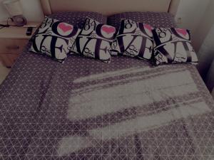 a bed with a purple comforter and pillows at Apartman Anamaria in Gospić