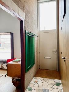 La salle de bains est pourvue d'un rideau de douche vert et d'une porte. dans l'établissement Industriële WOW! Privé studio-39m2-Eigen ingang, à Amsterdam