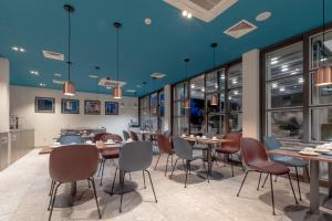 a restaurant with tables and chairs and blue ceilings at Hotel Nestos in Omiš