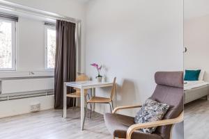 uma sala de estar com uma mesa e uma cadeira em Part-Time Home Slagsta Strand em Norsborg