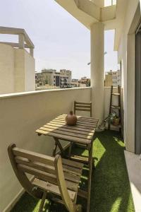 una mesa de madera y una silla en el balcón en Bora Bora Apartamento familiar San Juan Playa, en El Campello