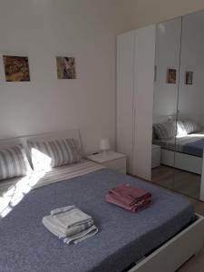 biała sypialnia z łóżkiem i ręcznikami w obiekcie Tigullio Vacations - Flavia beach apartment w mieście Lavagna