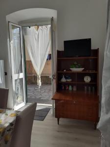 un soggiorno con TV, cassettiera e porta scorrevole in vetro di Tigullio Vacations - Flavia beach apartment a Lavagna