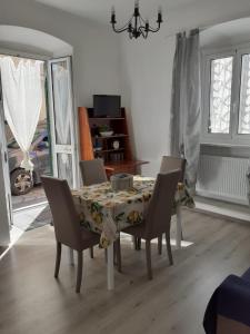 stół jadalny z krzesłami i ściereczką stołową w obiekcie Tigullio Vacations - Flavia beach apartment w mieście Lavagna