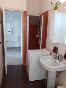 W łazience znajduje się umywalka, toaleta i prysznic. w obiekcie Tigullio Vacations - Flavia beach apartment w mieście Lavagna