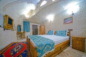 a bedroom with a bed in a stone room at Elysee Cave House in Goreme