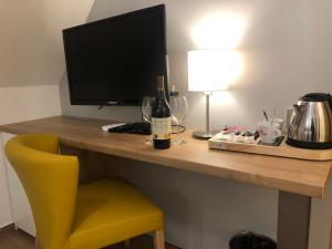 a desk with a computer monitor and a yellow chair at Hotel Slavia in Boskovice