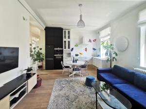 ein Wohnzimmer mit einem blauen Sofa und einem Tisch in der Unterkunft Retro Apartment in Sopot Center in Sopot