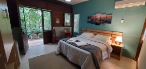 a bedroom with a large bed with blue walls at Stolz Chales in Guarda do Embaú