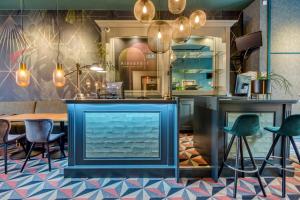 un restaurant avec un bar bleu avec des chaises et une table dans l'établissement Hotel Alexander, à Amsterdam