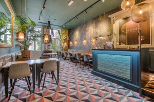a restaurant with tables and chairs and a fireplace at Hotel Alexander in Amsterdam