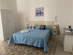 una camera da letto con letto con lenzuola e cuscini blu di La casetta di Mavi a Palermo