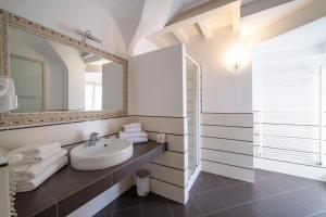 a white bathroom with a sink and a mirror at Albergo Diffuso Vulcano Village in Castro +115 photos
