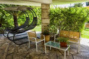 萊切的住宿－Il Giardino Di Flora - Piscina & Jacuzzi，庭院配有两把椅子、一张桌子和一把遮阳伞