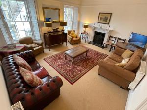 a living room with leather furniture and a fireplace at Kelso cobbles in Kelso