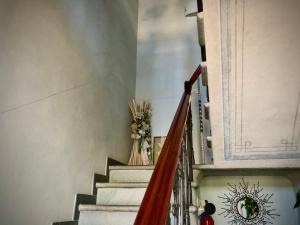 Una escalera con un jarrón de flores. en B & B Da Ferro en Massarosa