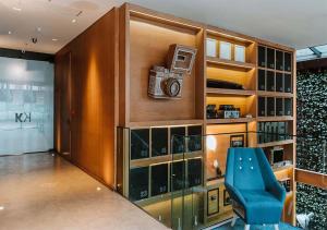 a living room with a blue chair and a book shelf at The Click Clack Hotel Bogotá in Bogotá