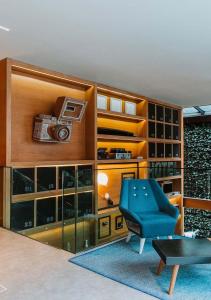 a living room with a blue chair and a table at The Click Clack Hotel Bogotá in Bogotá