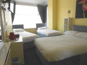 a hotel room with two beds and a window at Shore Stay Guest House in Blackpool