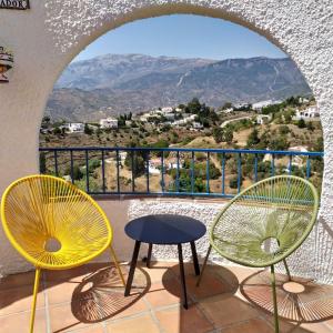 two chairs and a table on a balcony with a view at B&B la Madrugada in Cómpeta
