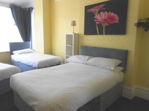 um quarto com duas camas e uma pintura de flores na parede em Shore Stay Guest House em Blackpool