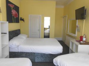 a hotel room with two beds and a tv at Shore Stay Guest House in Blackpool
