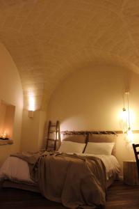 um quarto com uma cama grande e tectos abobadados em Fondo Vito em Gravina in Puglia