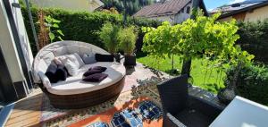 un patio con un sofá circular en una terraza en Jagd trifft Moderne & Boutique Jardin Ferienhaus, en Annaberg im Lammertal