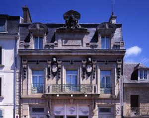 a building with a clock on the front of it at Hôtel Vintage in Quimperlé