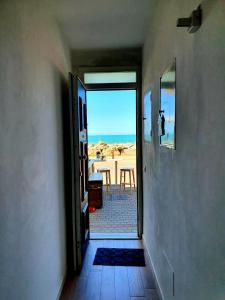 - une porte ouverte menant à une chambre avec vue sur la plage dans l'établissement Annemarie, à Marina di Pisa