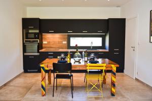 a kitchen with a wooden table and yellow chairs at Casa di Neshama Gabriella in Saint-Florent +11 photos