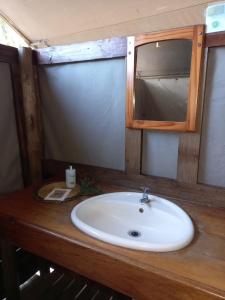 eine Badezimmertheke mit einem Waschbecken und einem Spiegel in der Unterkunft Mankwe Camping in Chiro Pan
