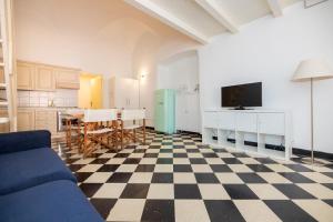 a kitchen with a blue couch and a checkered floor at Le Casasse "Grecale" in Varigotti