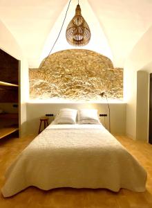 1 dormitorio con 1 cama con pared de piedra en Casa Elvira, en Torroella de Montgrí