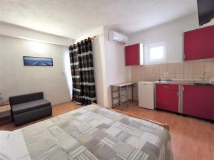 ein kleines Zimmer mit einem Bett und einer Küche in der Unterkunft Apartmani Divić in Drvenik