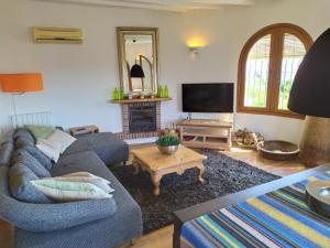 a living room with a couch and a fireplace at B&B la Madrugada in Cómpeta