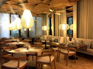 un restaurante con mesas, sillas y lámparas de araña en Blue Diamond Club at Movich Cartagena, en Cartagena de Indias