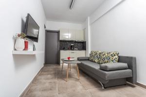 a living room with a couch and a table at Halkidiki beach apartments 1 Nea Kallikratia Vergia beach in Nea Kalikratia