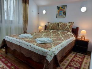 a bedroom with a bed with towels on it at Pensiunea Albina in Sînnicoară