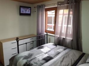 um quarto com uma cama e uma janela em Casa Mota Pinto em Castro Daire
