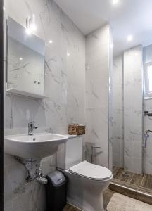 a white bathroom with a sink and a toilet at Halkidiki beach apartments 1 Nea Kallikratia Vergia beach in Nea Kalikratia