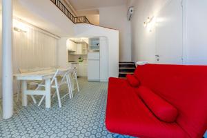 un soggiorno con divano rosso e tavolo di Le Casasse "Vico Mendaro 10" a Varigotti