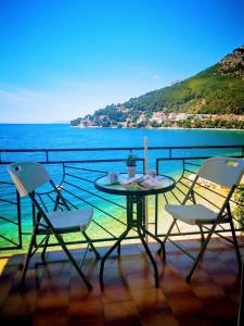 una mesa y sillas en un balcón con vistas al océano en Apartmani Divić, en Drvenik
